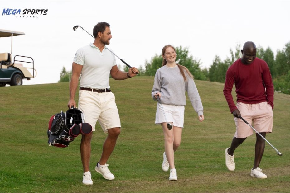 Three golfers wearing golf clothes walk on a grassy course with trees and a cart in the background